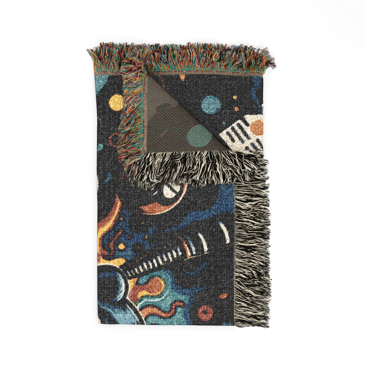 Folded woven blanket showing fringe and colorful artwork.