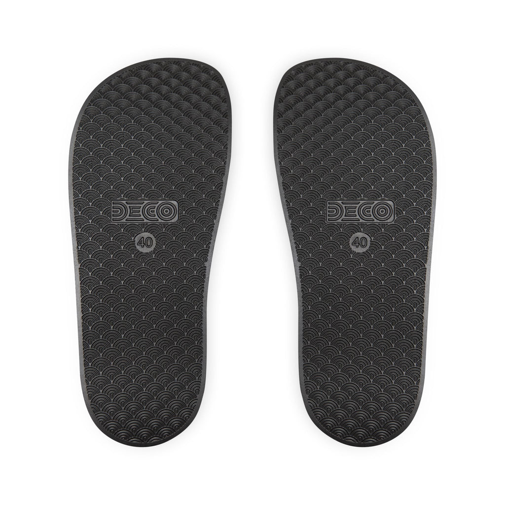 Black textured soles of a pair of slides.