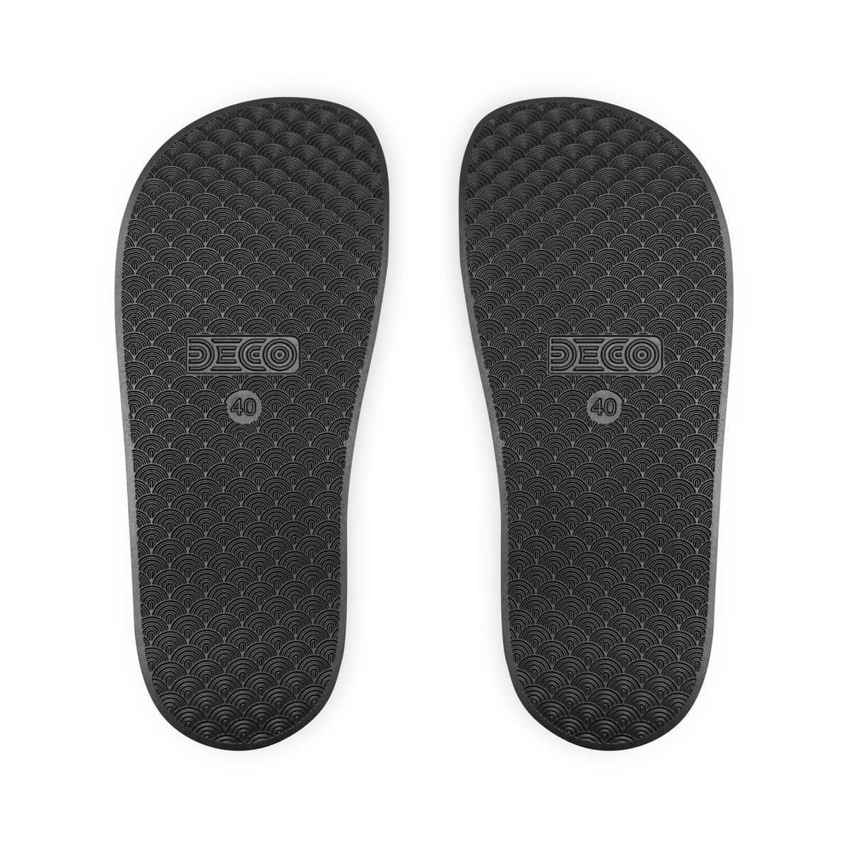 Black textured soles of a pair of slides.