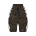 A pair of cropped athletic shorts featuring a brown and black leopard print pattern, with white double stripes running down the sides and a small white 'K' logo near the lower hem, shown against a plain white background.
