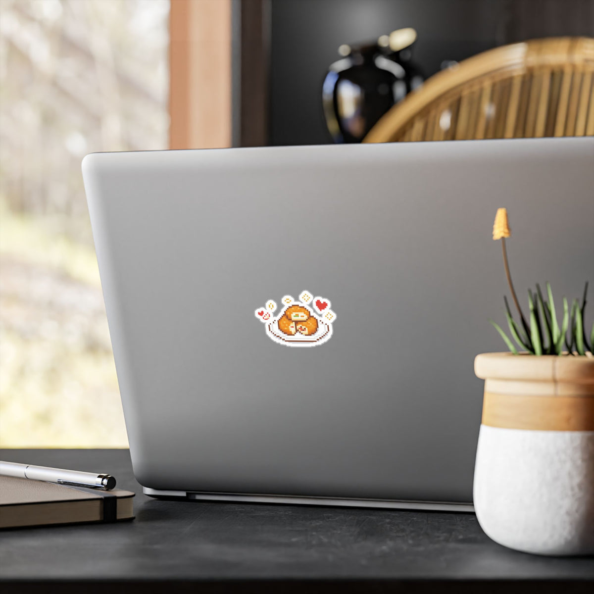 Sloth and apple-fritter sticker displayed on a laptop.